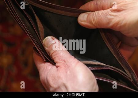 A man holds a wallet in his hands. The man shows that there is no money there. Stock Photo