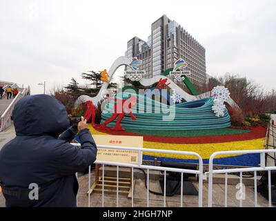 BEIJING, CHINA - JANUARY 21, 2022 - People take photos in front of a flowerbed themed 'Green Winter Olympics' at the northeast corner of Changan Avenu Stock Photo