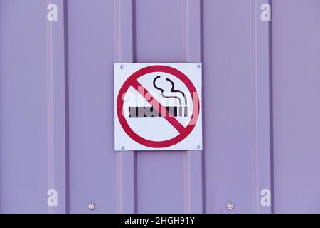 No smoking sign on profiled sheeting wall, concept of health care, smoking cessation. Smoking cigarette in a crossed out red circle. Stock photo with empty space for text. Stock Photo