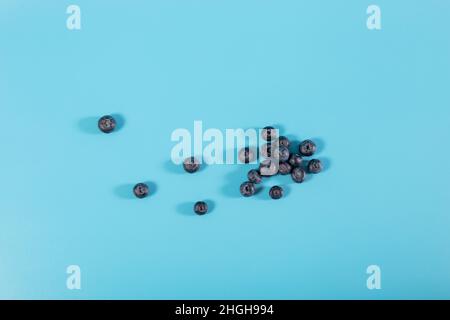 Flatlay of heap blueberries close up on blue background with copy space. Stock Photo