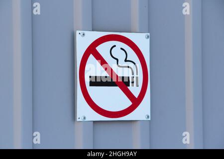 No smoking sign on profiled sheeting wall, concept of health care, smoking cessation. Smoking cigarette in a crossed out red circle. Stock photo with empty space for text. Stock Photo