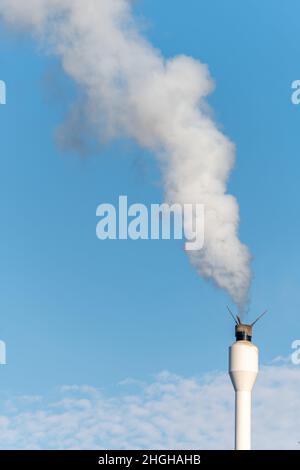 Chimney with a release of white smoke. Wood-fired boiler in a