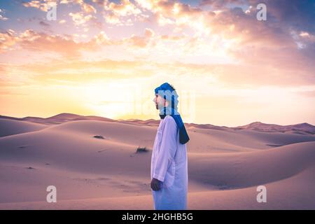 Young arabic man wearing traditional berber clothes in the Sahara Desert of Merzouga, Morocco Stock Photo
