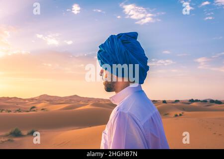 Young arabic man wearing traditional berber clothes in the Sahara Desert of Merzouga, Morocco Stock Photo