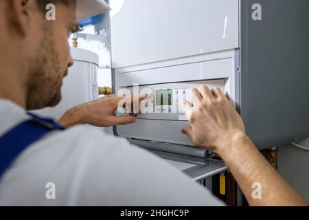 worker set up new central gas heating boiler for home Stock Photo