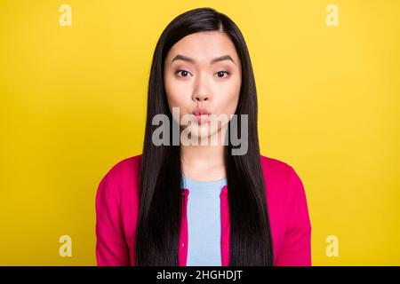 Photo of lovely brunette hair young lady blow kiss wear pink sweater isolated on yellow background Stock Photo