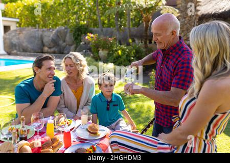 Caucasian three generation family enjoying lunch in the garden Stock Photo