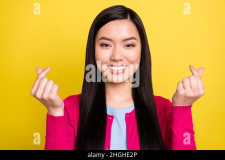 Photo of flirty brunette hair millennial lady show heart wear pink sweater isolated on yellow color background Stock Photo