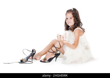 little girl trying on the big shoes Stock Photo