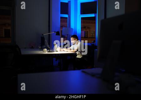 Workaholic man stay in office overtime prepare for business presentation or startup launch at night Stock Photo