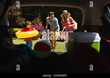 Happy caucasian family putting all their luggage in car Stock Photo