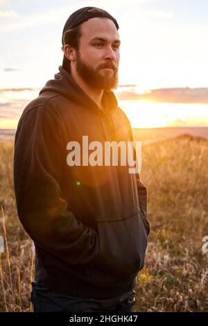 Handsome guy in black wear having rest outdoors, in nature. Male after sport, enjoy the rest. Relaxed man jogger, leisure after training. outdoor port Stock Photo