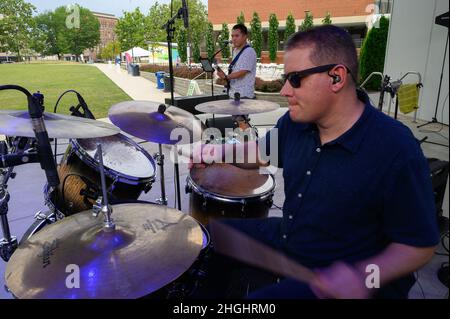 Tech. Sgt. Andy Wendzikowski, drummer, and Airman 1st Class Christopher Arellano perform a sound check at Levitt Pavilion in Dayton, Ohio, on Aug. 7, 2021, prior to a scheduled performance of the Air Force Band of Flight’s rock ensemble Flight One. Stock Photo