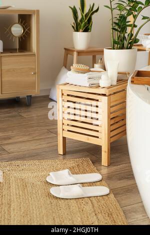 Wooden chest of drawers with supplies in stylish bathroom Stock Photo