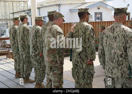 Lt. Col. Frank Tantillo, commander, Task Force Iron Gray, presents Army Achievement Medals to eight U.S. Navy Sailors assigned the Maritime Expeditionary Security Force Eleven (MSRON-11) during an awards ceremony at Camp Lemonnier, Djibouti, Aug. 12, 2021. The Sailors were awarded for contributing to training U.S. Army Soldiers attached to Dagger Company, 1-102nd Infantry Regiment (Mountain) on various tasks such as swimming assessments, tactical combat casualty care and basic small boat operations. Stock Photo