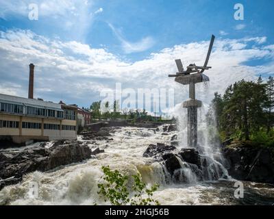 HONEFOSS, NORWAY - 7 JUN 2019: Roaring waterfalls on river with large modern sculpture. Stock Photo