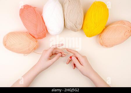 Human hand holding with yarn and crochet hook. Flat Lay background. Stock Photo