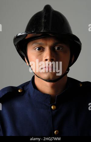 Mumbai; Maharashtra; India- Asia; Dec. 26; 2009 - Male model studio shot Indian Fireman in uniform white background Stock Photo