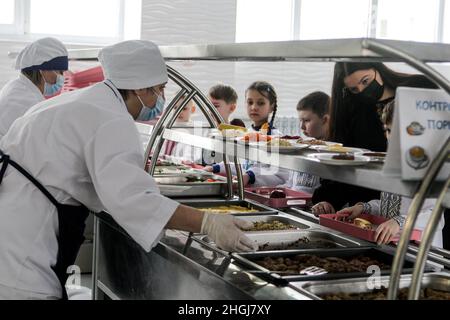 KYIV, UKRAINE - JANUARY 21, 2022 - Cooks serve food to students in the canteen of N209 Suziria school, Kyiv, capital of Ukraine. Schools are now intro Stock Photo