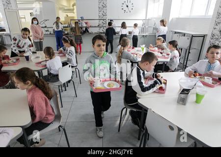 KYIV, UKRAINE - JANUARY 21, 2022 - Students have dinner in the canteen of N209 Suziria school, Kyiv, capital of Ukraine. Schools are now introducing t Stock Photo