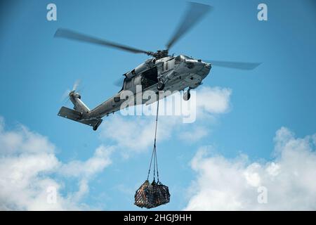 PACIFIC OCEAN (April 19, 2021) A U.S. Navy MH-60S Sea Hawk assigned to Helicopter Sea Combat Squadron 4 sling loads cargo during a vertical replenishment-at-sea with amphibious transport dock USS Portland (LPD 27), Aug. 14. Marines and Sailors of the 11th MEU and Essex Amphibious Ready Group (ARG) are underway conducting routine operations in U.S. 3rd Fleet. Stock Photo