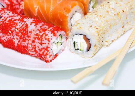 Sushi rolls wrapped in nori. Sushi sticks next to the rolls. Traditional Japanese food Stock Photo