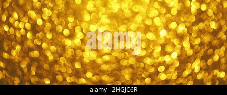 Abstract festive elegant background, banner of blurred with bokeh lights on golden background, defocused Stock Photo