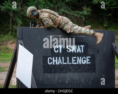 Tech. Sgt. Leo Otero, 103rd Security Forces Squadron, climbs over a wall during the Connecticut SWAT Challenge in East Granby, Connecticut, Aug. 18, 2021. The competition brings together tactical operators from across the nation to train SWAT weapons tactics, movements, and physical fitness. Stock Photo