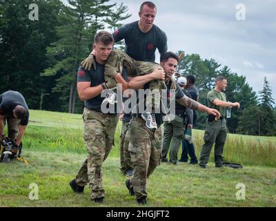 U.S. Air Force Staff Sgt. Chad Jarvis (left) and Tech. Sgt. Leo Otero carry Staff Sgt. Collin Gallagher-Paeth, all assigned to the 103rd Security Forces Squadron, during the physical training portion of the Connecticut SWAT Challenge in West Hartford, Connecticut, Aug. 19, 2021. The competition brings together tactical operators from across the nation to train SWAT weapons tactics, movements, and physical fitness. Stock Photo