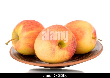 Three red juicy apples on a clay plate, macro, isolated on white. Stock Photo
