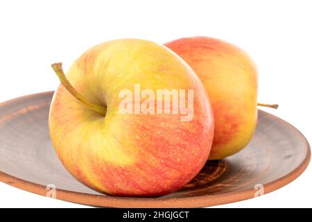 Three red juicy apples on a clay plate, macro, isolated on white. Stock Photo