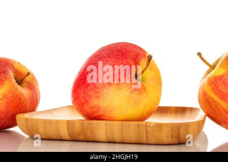 Three red juicy apples on a wooden tray, macro, isolated on white. Stock Photo