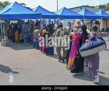 Afghan evacuees line up to be processed at Ramstein Air Base, Germany, Aug. 21, 2021. Ramstein Air Base is providing safe, temporary lodging for evacuees from Afghanistan as part of Operation Allies Refuge. This operation is facilitating the quick, safe evacuation of U.S. citizens, Special Immigrant Visa applicants and other at-risk Afghans from Afghanistan. Evacuees will receive support, such as temporary lodging, food, medical care as well as religious care at Ramstein Air Base while preparing for onward movements to their final destinations. Stock Photo