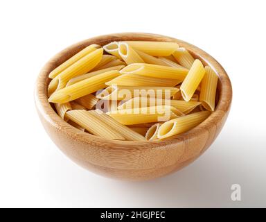 Uncooked penne pasta in wooden bowl isolated on white background with clipping path Stock Photo