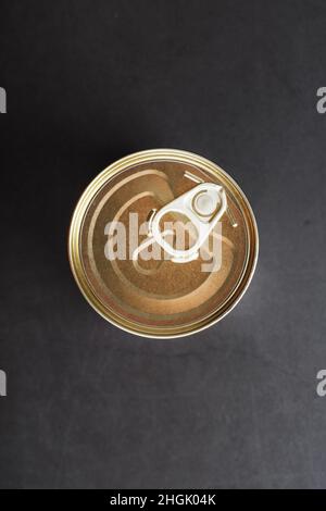 The lid of a metal tin can on a black background. Top view Stock Photo