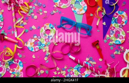 Carnival birthday party. Confetti and serpentines on bright pink background, overhead view. Holiday celebration and decoration Stock Photo