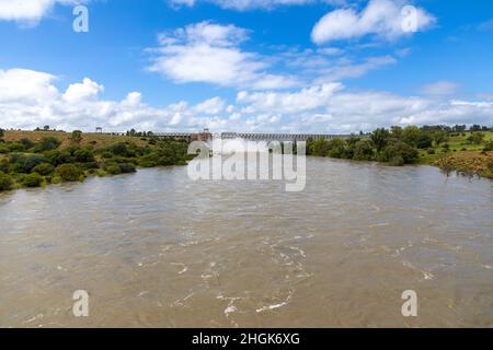 Vaal River in flood with the open Sluice gates  and dam wall of the Vaaldam in South Africa after good rains in the background Stock Photo