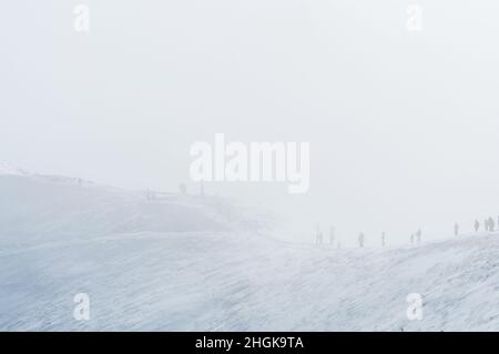 Tatra Mountains. People walking on a ridge shrouded in a cloud. Winter landscape. Stock Photo