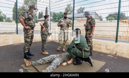 U.S. Navy Petty Officer 2nd Class Korina Mabile, and a member of the Utah guard interpret Tactical Combat Casualty Care to the soldiers of the Royal Moroccan Armed Forces (FAR) near Kenitra, Morocco, Aug. 30, 2021. The focus of the Humanitarian Mine Action course is to implement a train-the-trainer period of instruction that develops the FAR’s skills in order to train their own personnel in preparation for future operations. Stock Photo