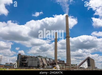 Industrial site with two large smoke stacks pumping gas into the atmosphere Stock Photo