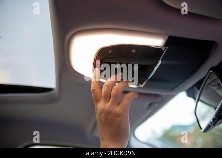 hand push sos button on ceiling console in modern car Stock Photo