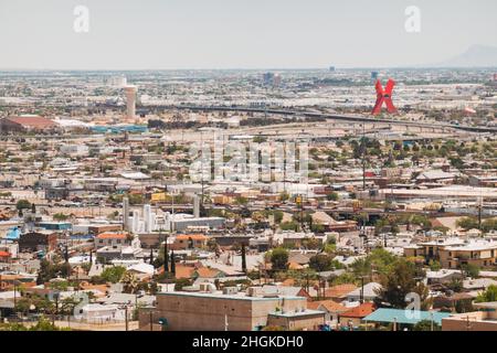 the US-Mexico border carves a line between El Paso, TX and Ciudad Juárez, Mexico, where a large red 'X' sculpture, 'La Equis' can be seen Stock Photo