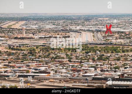 the US-Mexico border carves a line between El Paso, TX and Ciudad Juárez, Mexico, where a large red 'X' sculpture, 'La Equis' can be seen Stock Photo