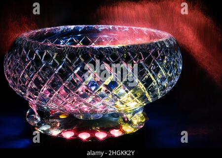 Pink fiber optic lights around a crystal bowl lit with colored lights from below Stock Photo
