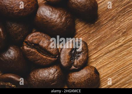 Coffee beans roasted on wooden background Close up macro copy space Stock Photo