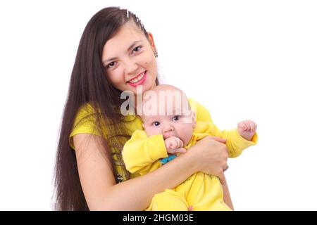 pretty happy young mother with the cute little baby dressed in yellow clothing Stock Photo