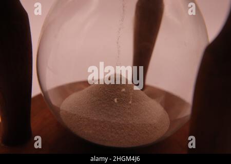 Hourglass spilling sand killing time counting Stock Photo