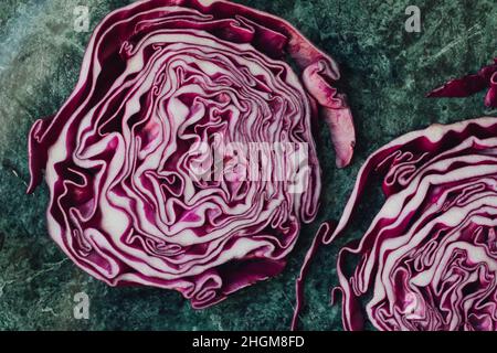 directly above shot of sliced red cabbage on a green table Stock Photo