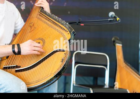 A man plays a traditional Ukrainian instrument at home. The musician plays the bandura. Stock Photo
