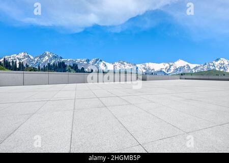 Empty square floor and snow mountains under blue sky Stock Photo